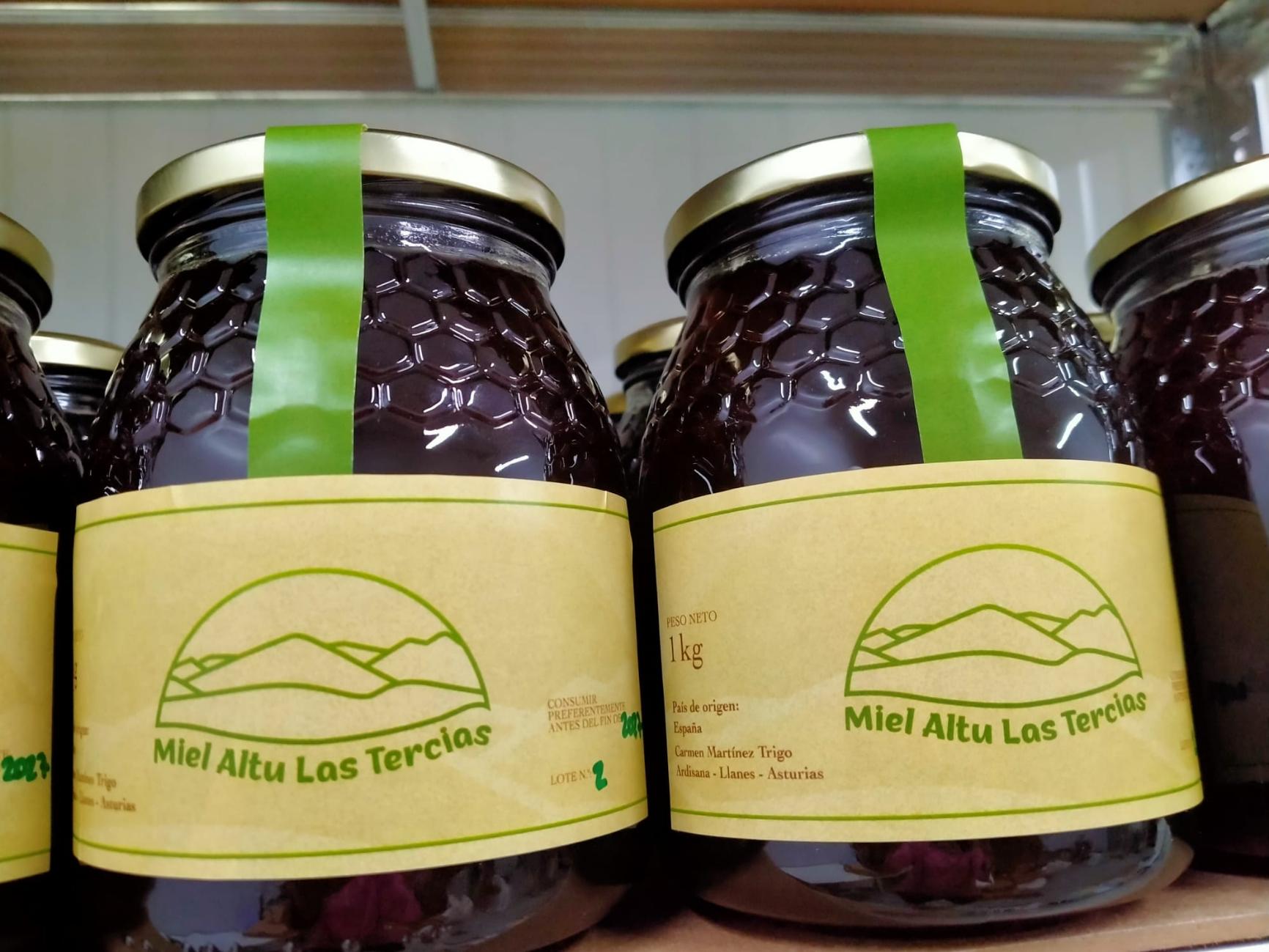 Dos tarros de miel oscura con tapa dorada, precinto verde y la etiqueta amarilla de Miel Altu Las Tercias.